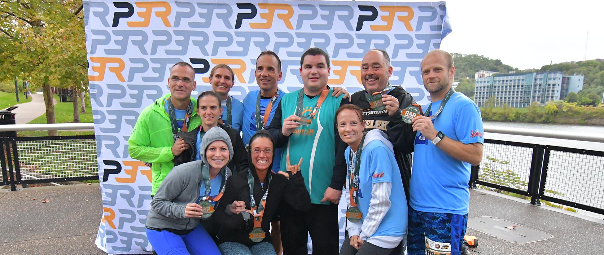 Group of runners posing together with their race medals after finishing the GAP Relay presented by UPMC Health Plan