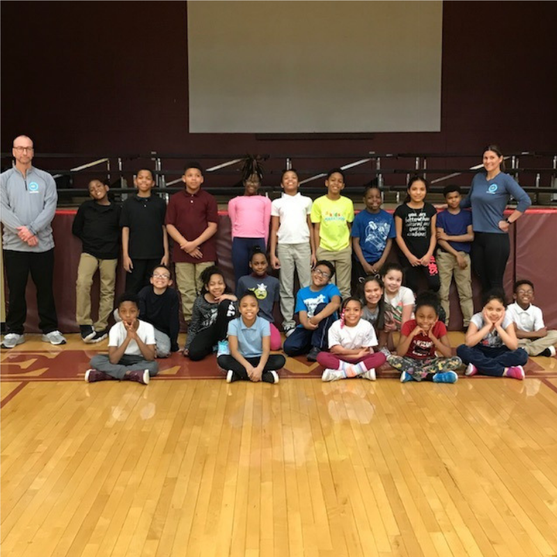 Group of students from Barrett Elementary School standing with their running team coaches