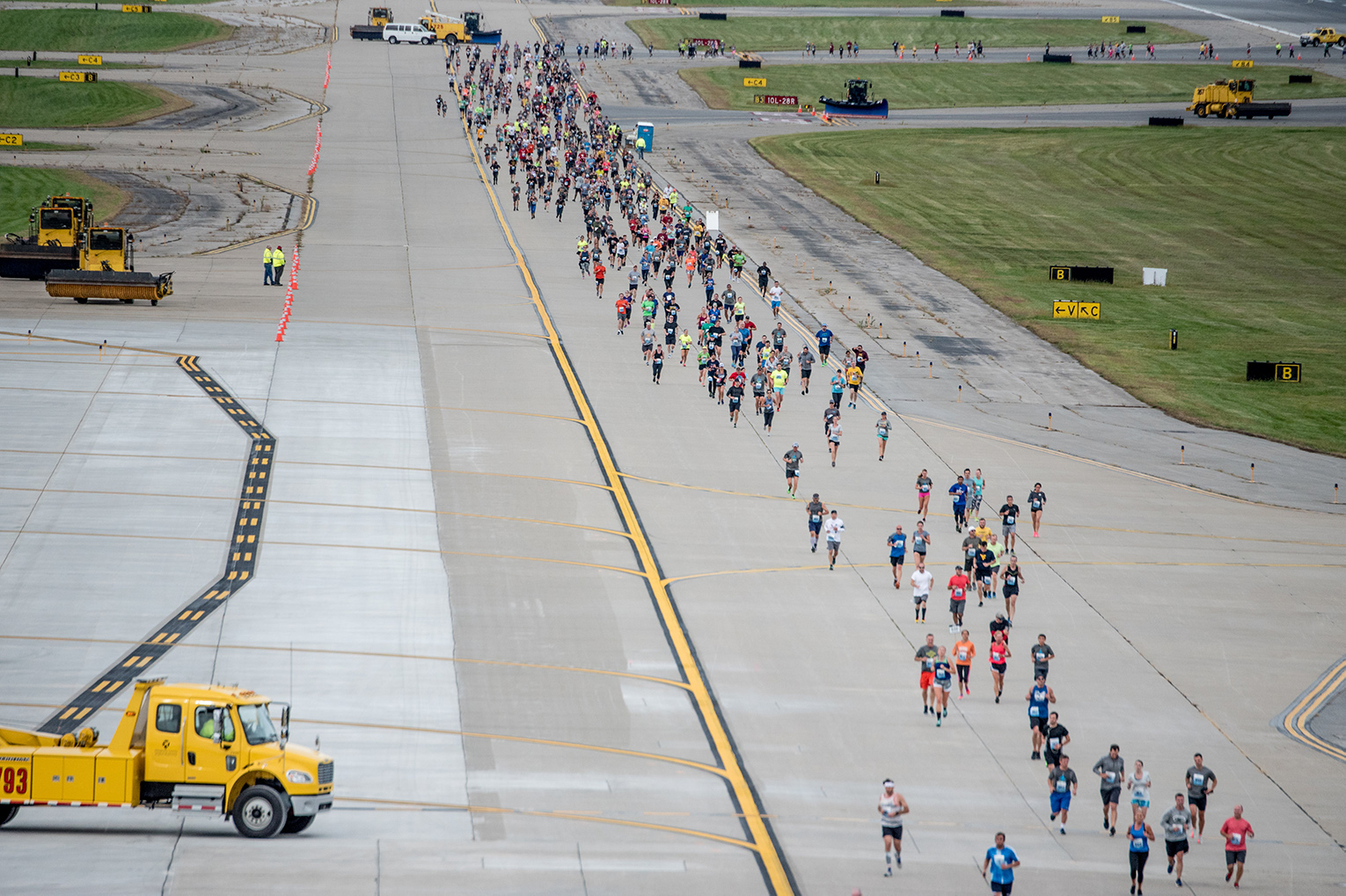 Large group of people running on the runway of Pittsburgh International Airport at the FlyBy 5K and 2-Mile Fun Run/Walk