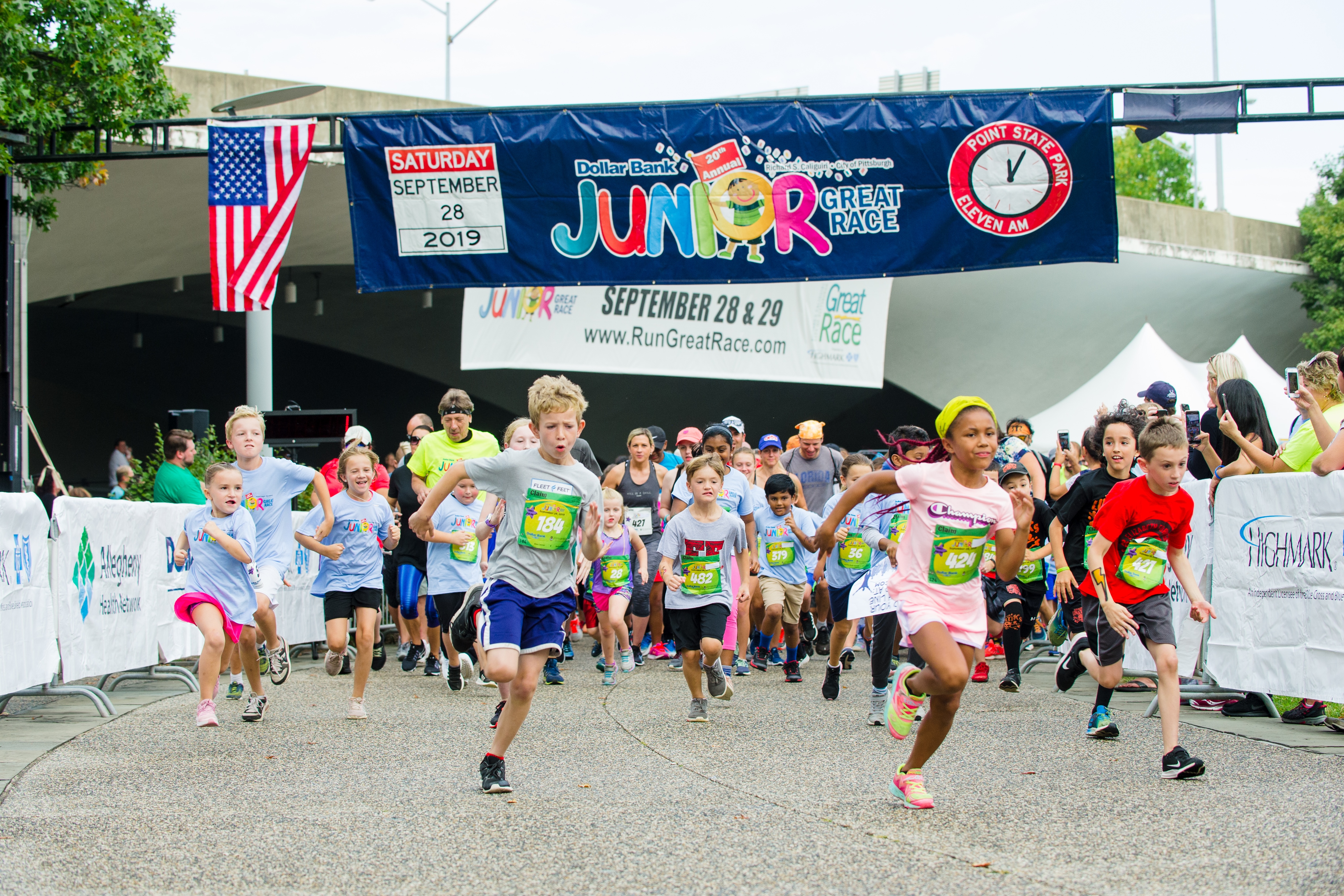 A large group of children running in the Dollar Bank Junior Great Race, which consists of the One-Mile Family Fun Run, Tot Trot, and Diaper Dash