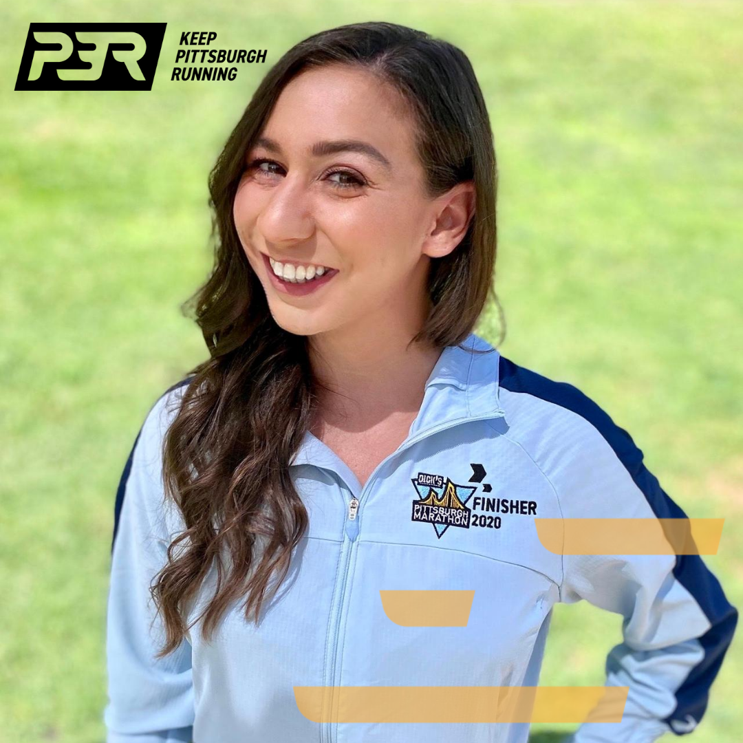 Jeanine McGuire wearing a Pittsburgh Marathon finisher jacket.