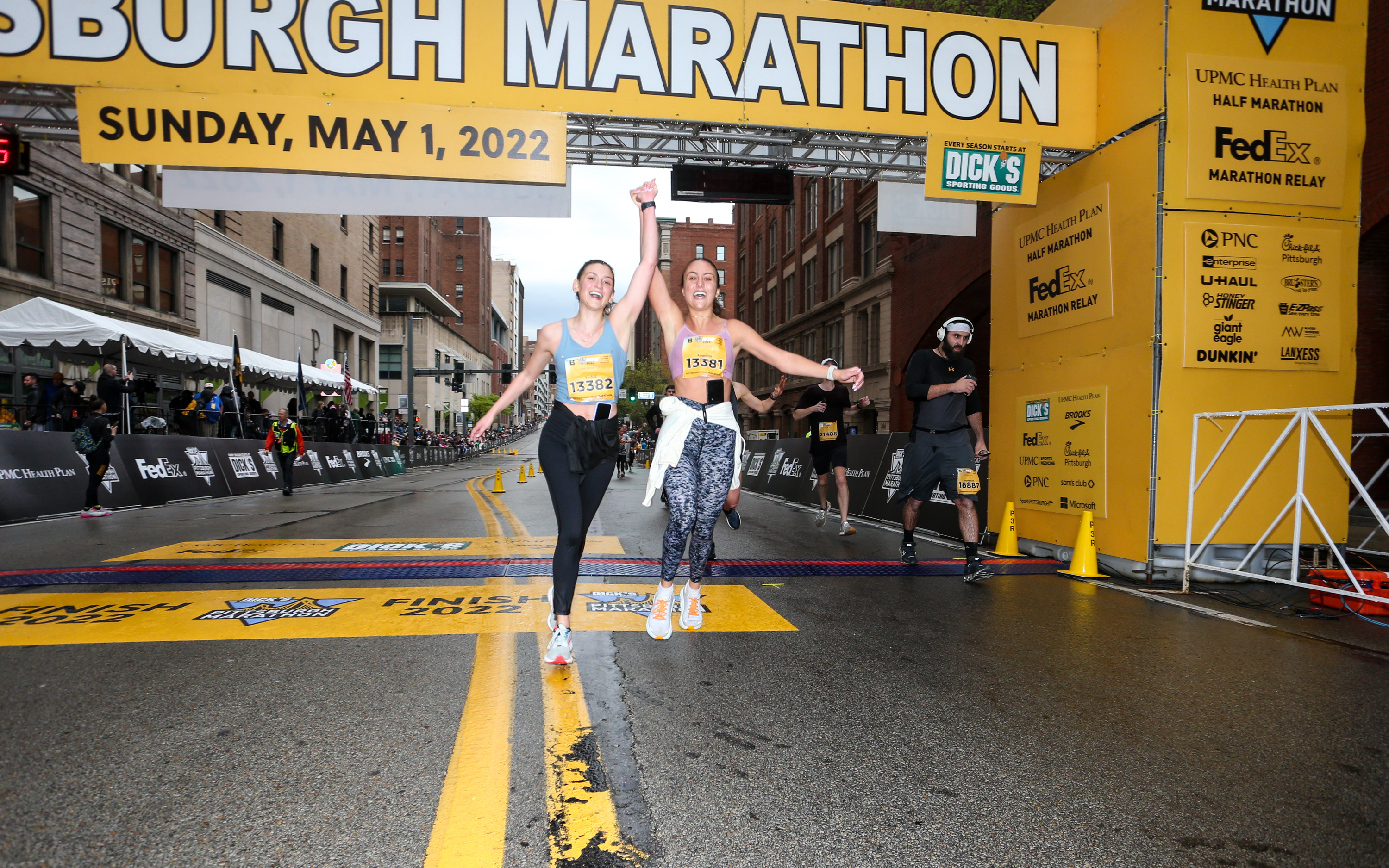 Two women cross the finish line at the 2022 DICK'S Sporting Goods Pittsburgh Marathon