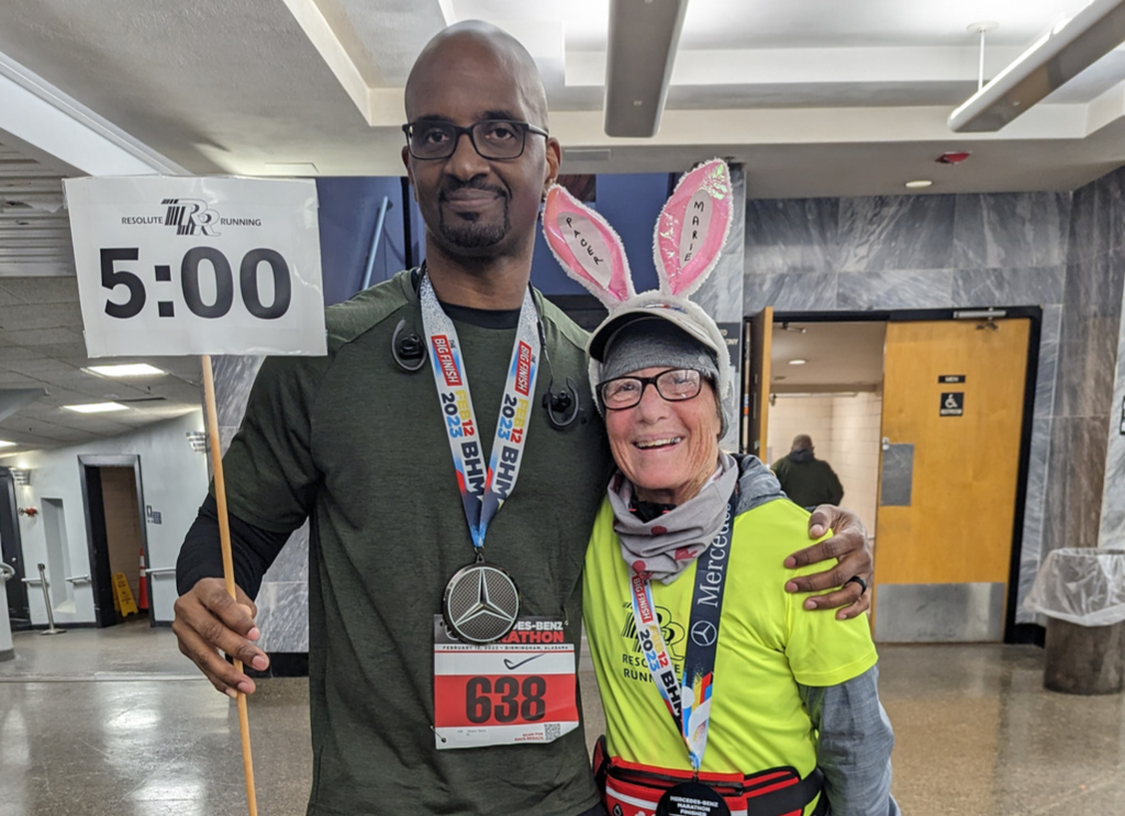 Marie stands with a 5:00 pace sign and bunny ears!