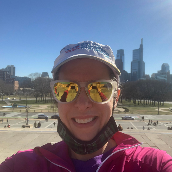 Sarah Lee-Faulker takes a selfie while on a run, wearing a pink jacket and white and gold sunglasses.