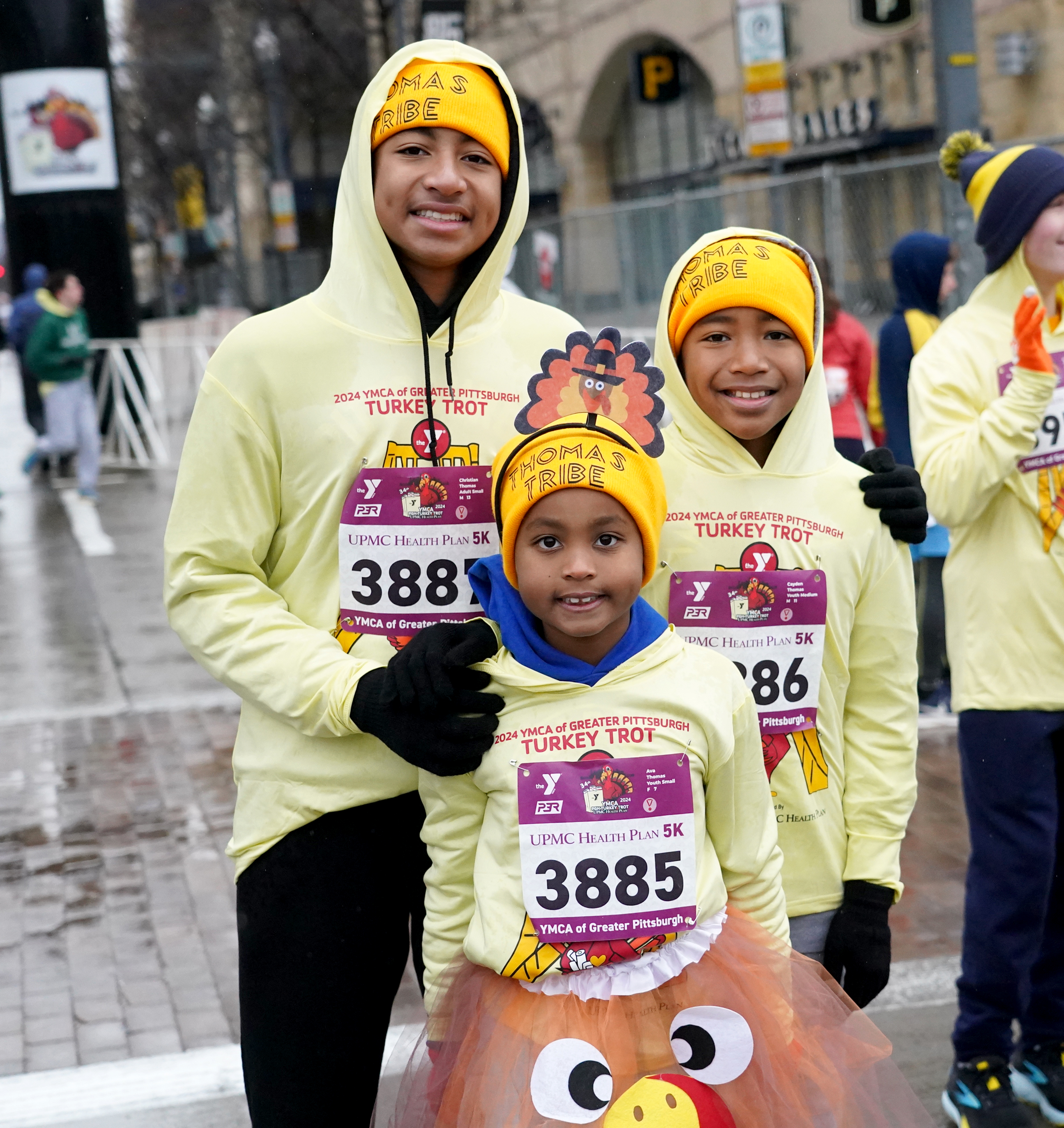 A family of runners huddle for a photo in the rainy weather.