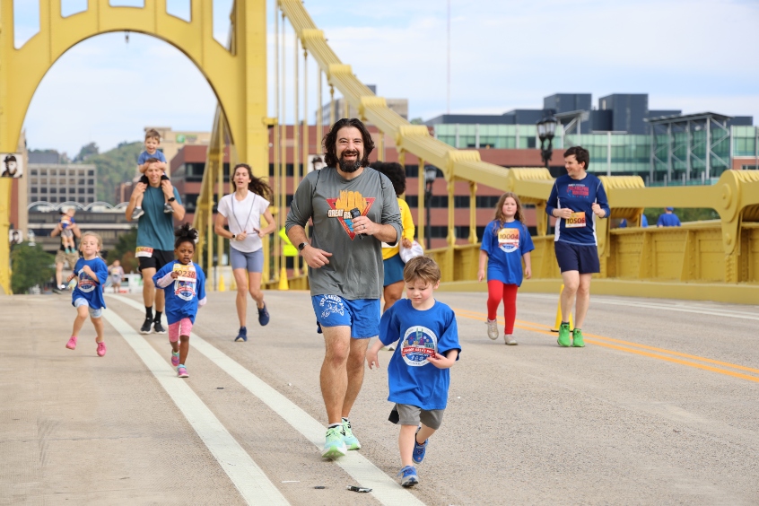 Families of runners coming across the Roberto Clemente Bridge