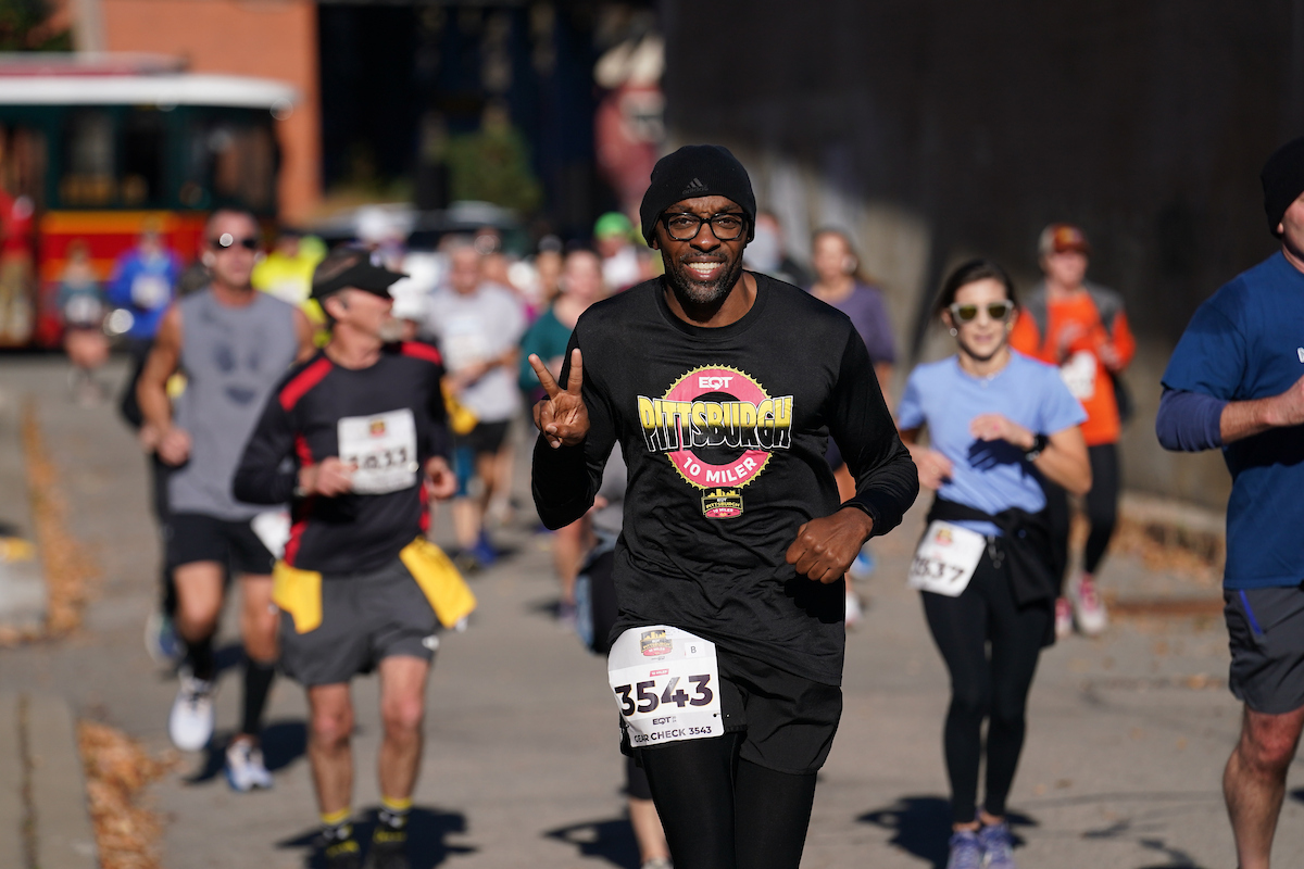 Man running while showing the peace sign
