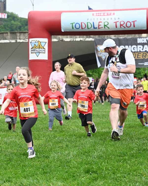 Young kids running in the Sheetz Pittsburgh Toddler Trot with other children running behind her