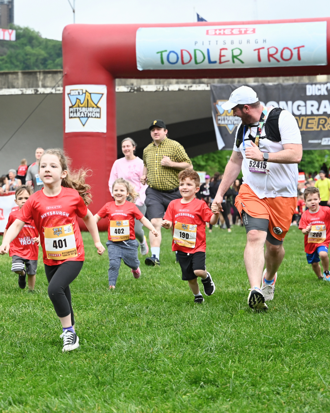 Young kids running in the Sheetz Pittsburgh Toddler Trot with other children running behind her