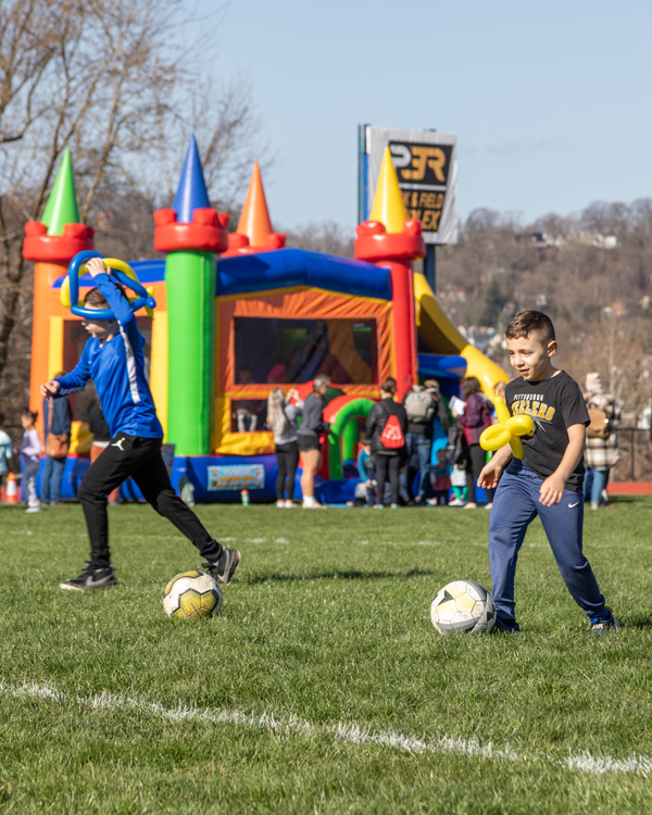 kids playing soccer with balloon hats