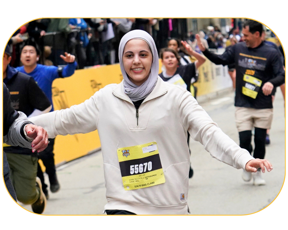 A runner at the 2026 UPMC Health Plan/UPMC Sports Medicine Pittsburgh 5K Run finish line