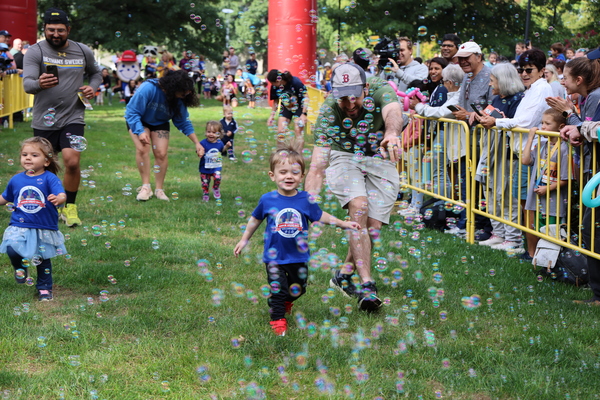 Kids running through bubbles during the Tot Trot